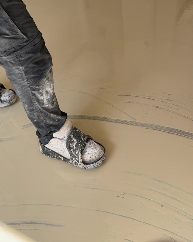 Fresh base coat being rolled across a garage floor
