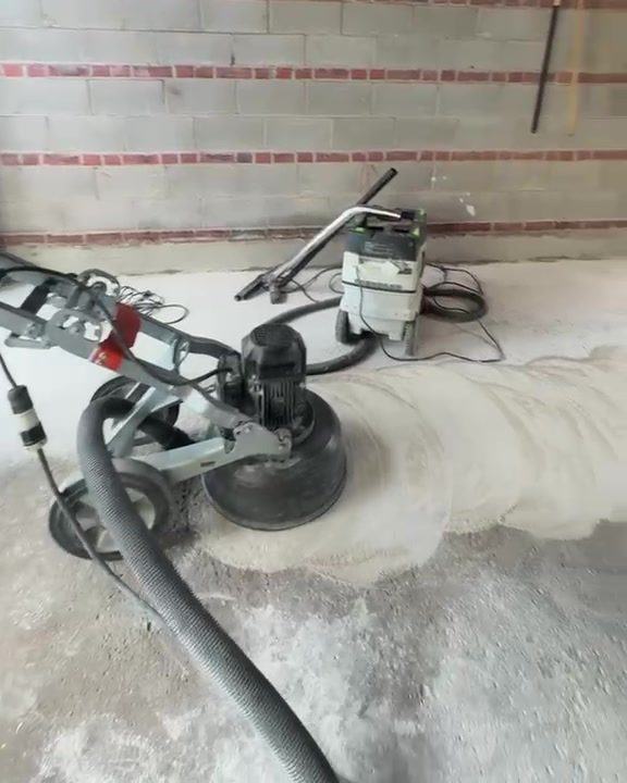 Diamond grinder and dust extractor on a garage floor
